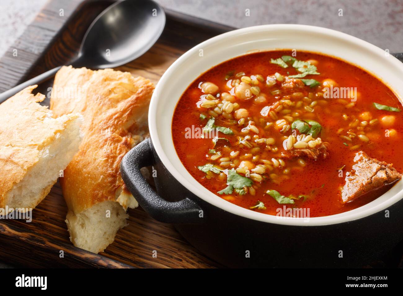 Chorba Frik è una zuppa tradizionale fatta di agnello, grano cracked, pomodori, cipolla, sedano, coriandolo, paprika, prezzemolo primo piano in un piatto sul tavolo Foto Stock