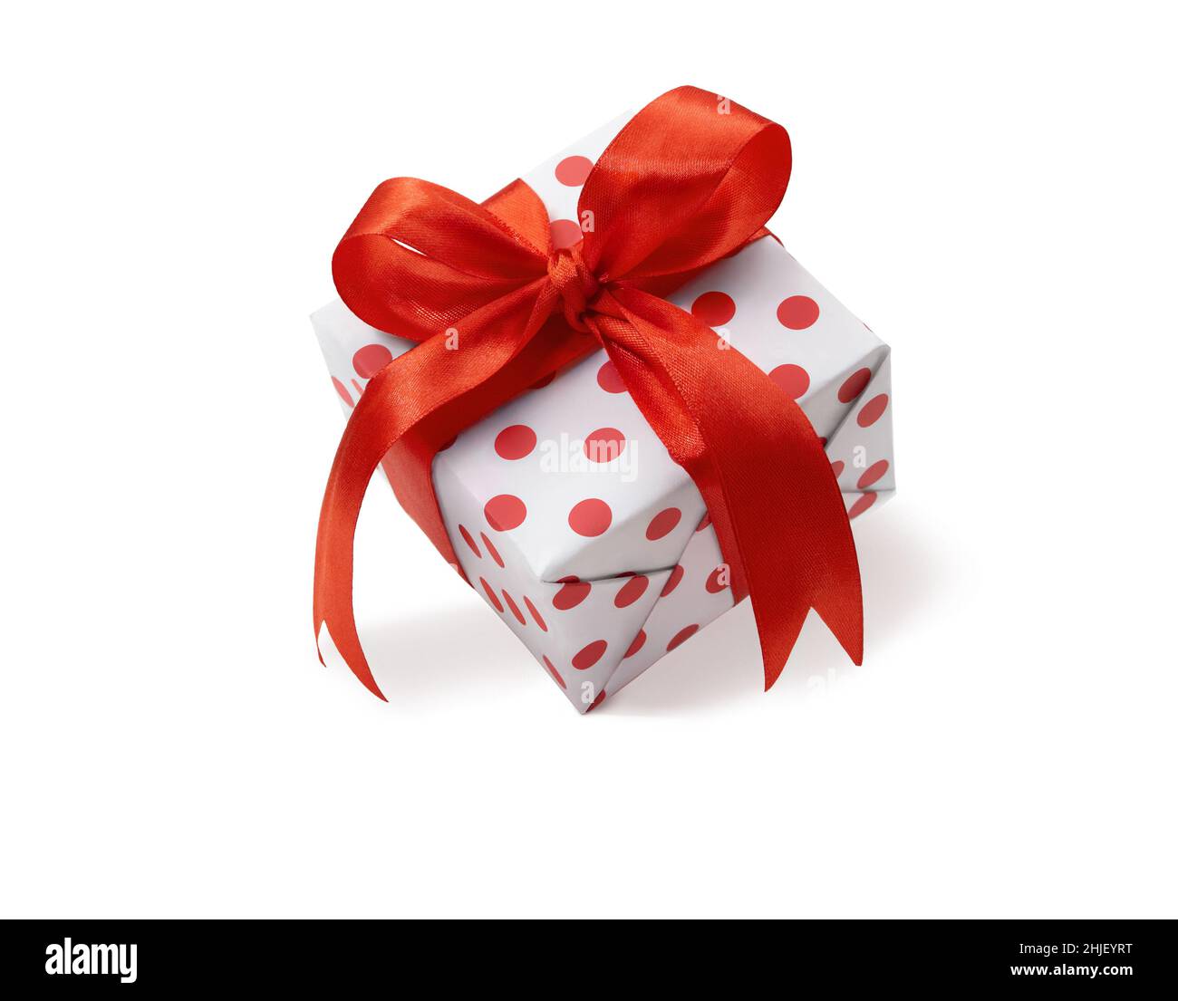 Confezione regalo chiusa per le feste con puntini e arco rosso su sfondo bianco isolato. Festa, San Valentino, Festa Internazionale della Donna e della Madre, Marzo 8, Bir Foto Stock