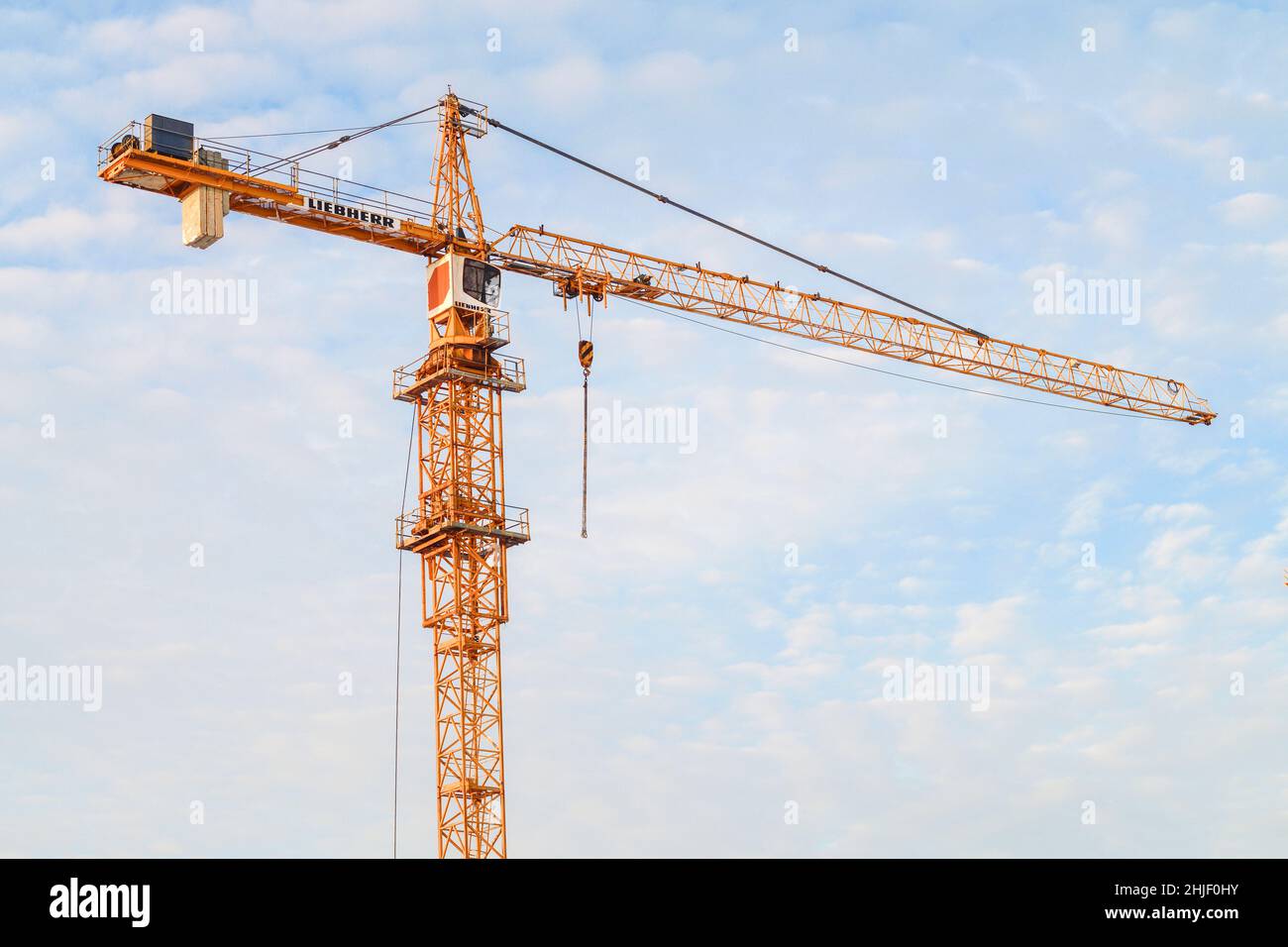 SAN PIETROBURGO, RUSSIA - 10 DICEMBRE 2021: Liebherr costruirà una gru di alto livello contro un cielo nuvoloso in una giornata invernale soleggiata Foto Stock