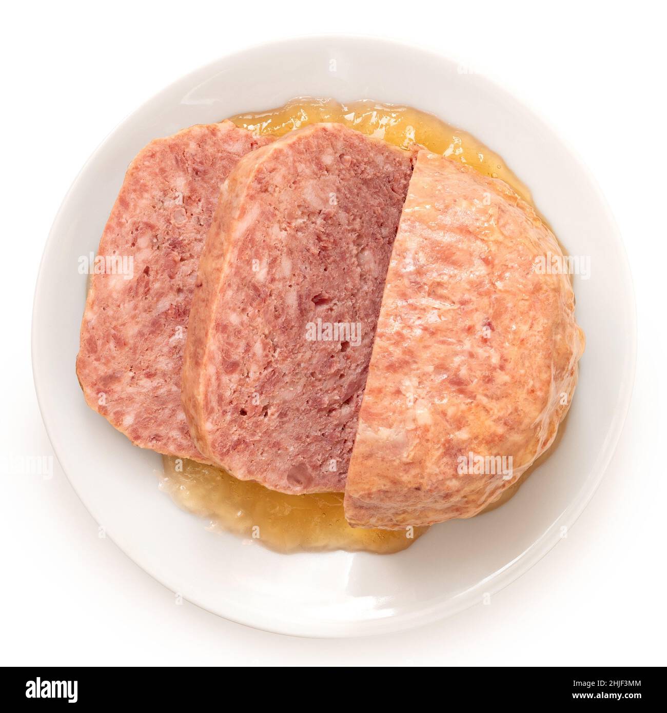 Carne di maiale affettata in scatola circondata da gelatina su piatto bianco isolato su bianco. Vista dall'alto. Foto Stock