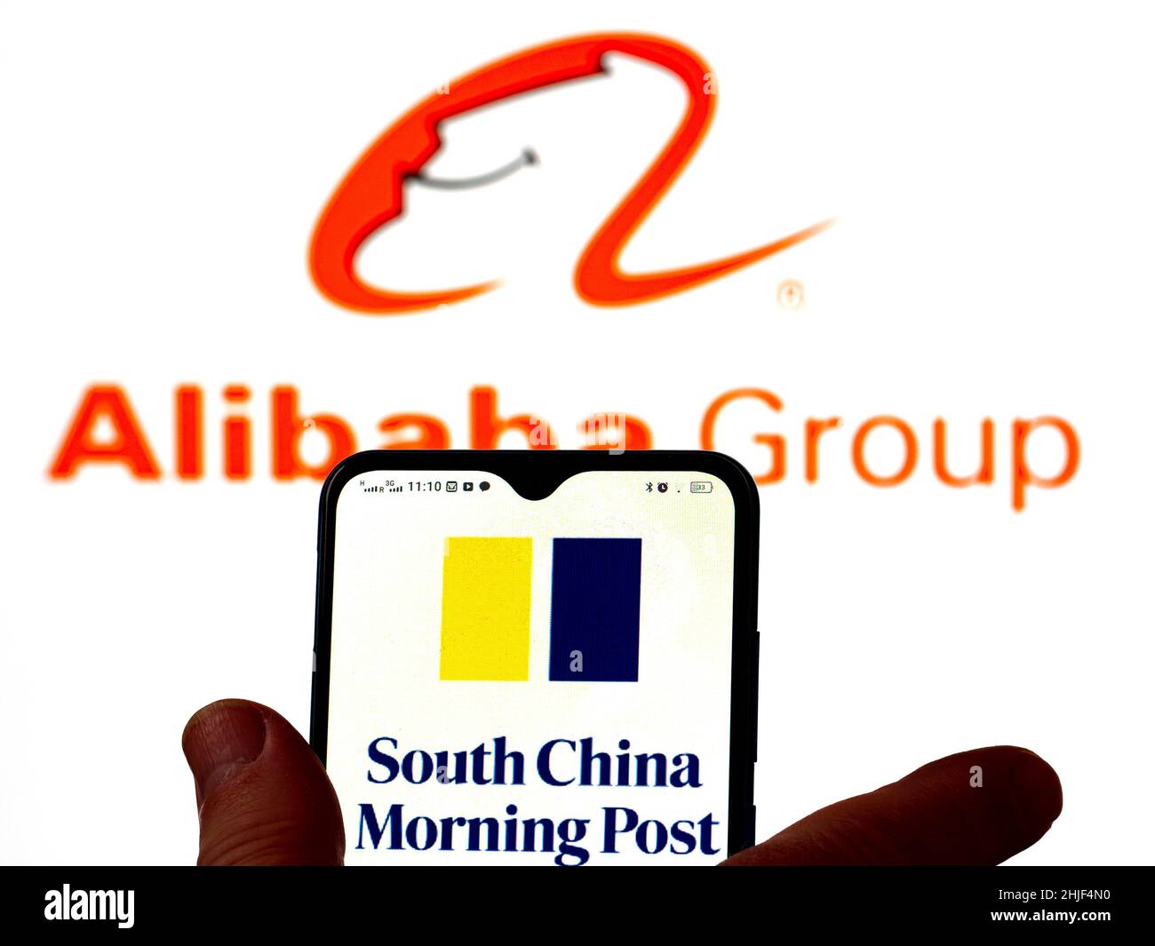 In questa foto, il logo SCMP (South China Morning Post) viene visualizzato sullo schermo di uno smartphone con il logo Alibaba Group sullo sfondo. Foto Stock