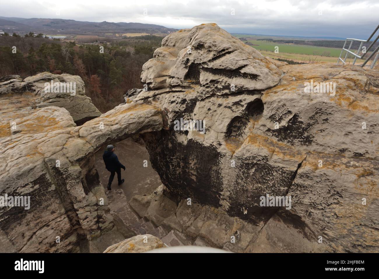 Blankenburg, Germania. 29th Jan 2022. I visitatori possono ammirare la vista sui monti Harz presso il castello di Regenstein. La pietra arenaria su cui un tempo sorgeva il castello della grotta è una destinazione popolare. Qui è possibile visitare i resti elencati del Castello di Regenstein, che è stato menzionato per la prima volta nel 1169. Dal 12th al 15th secolo fu sede del potere dei conti di Regenstein. Il totale di 32 stanze di roccia scolpite in arenaria, la maggior parte delle quali possono essere visitate, sono considerate una caratteristica speciale. Credit: dpa/dpa-Zentralbild/ZB/dpa/Alamy Live News Foto Stock