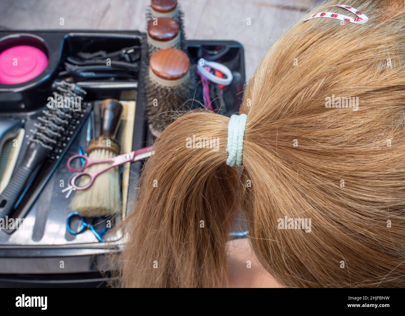 La donna ottiene una treccia fatta nel salone dei capelli Foto Stock