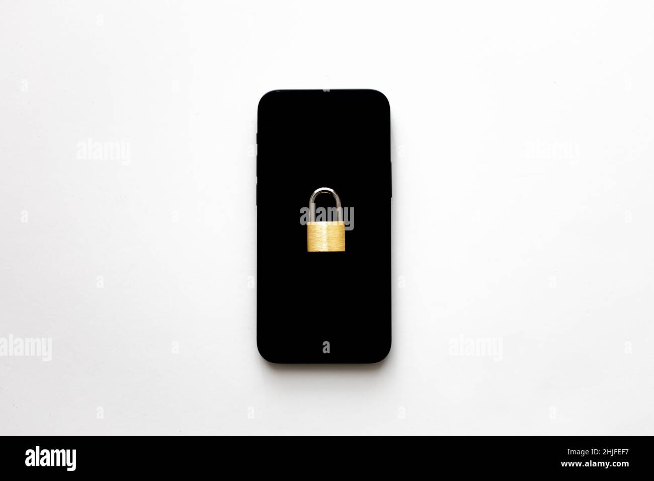 Uno smartphone nero isolato con un piccolo lucchetto su sfondo bianco. Idea di protezione del telefono. Concetto di protezione della privacy dei dati online. Foto Stock