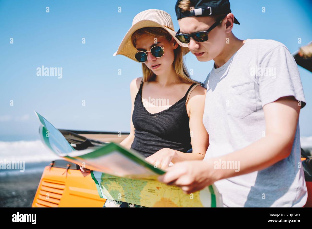 Giovane coppia di occhiali da sole che guarda la mappa Foto Stock