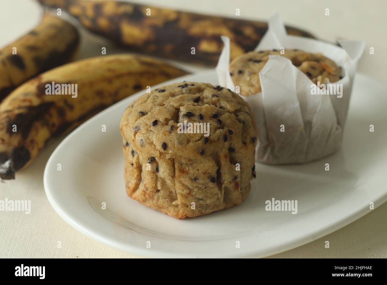 Muffin plantain. Uno spuntino sano con piante extra mature, farina integrale e semi di sesamo come ingredienti. Shot con muffin all'interno della pergamena Foto Stock