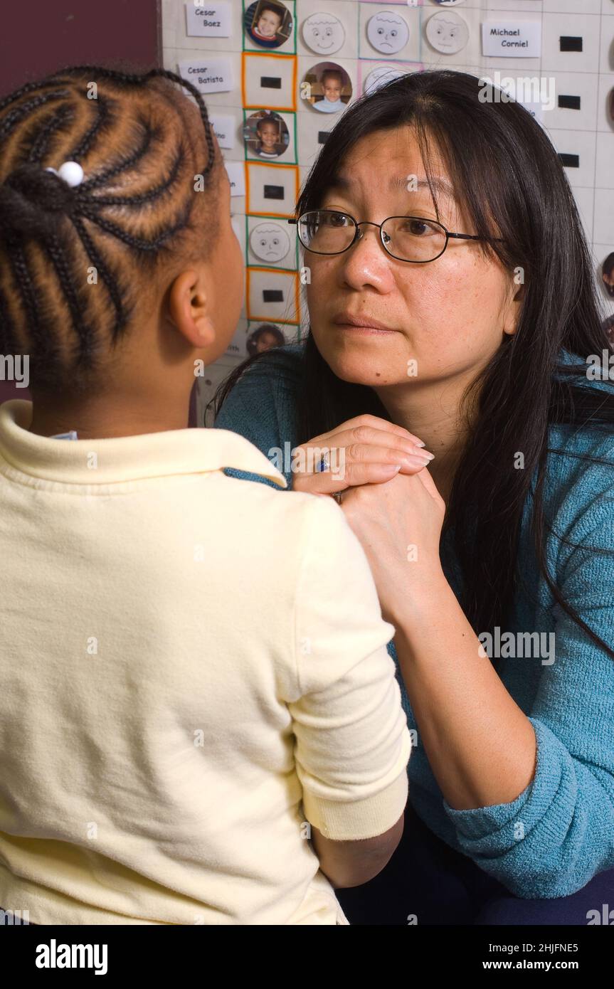 Istruzione Preschool classe 4-5 anni insegnante di sesso femminile che ascolta la ragazza, discussione sul comportamento o disputa in classe Foto Stock