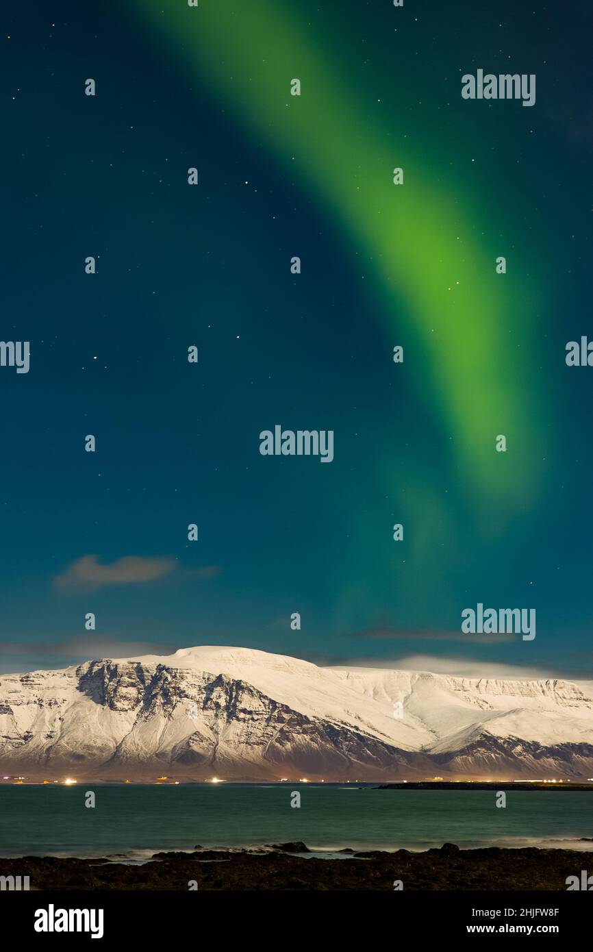 L'aurora boreale sopra il Monte Esja innevato nella capitale islandese, Reykjavic. Foto Stock