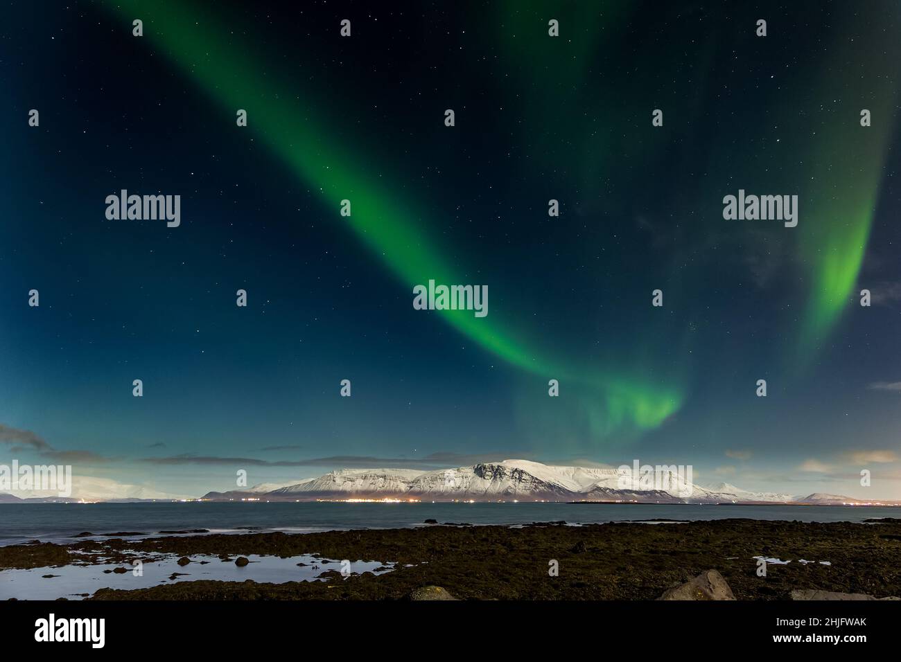L'aurora boreale sopra il Monte Esja innevato nella capitale islandese, Reykjavic. Foto Stock