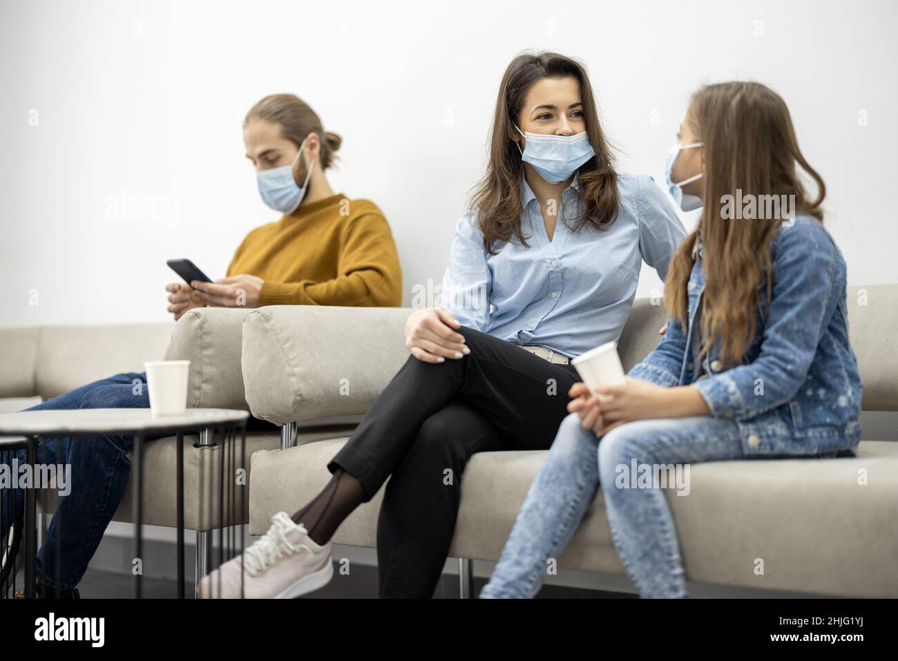 Persone sedute nella sala della clinica, in attesa di un appuntamento Foto Stock