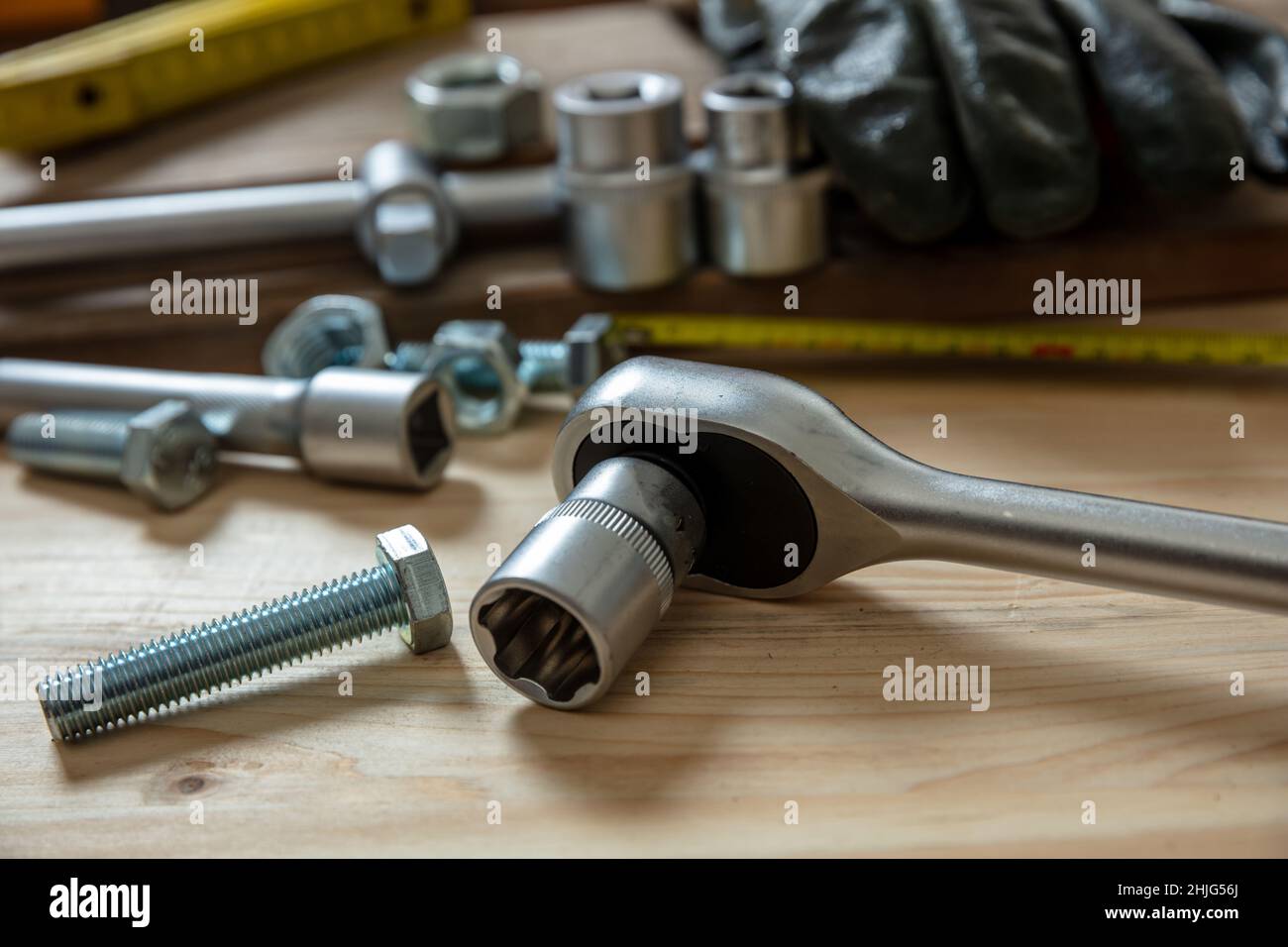 Chiave dinamometrica, attrezzatura con cricchetti reversibili su fondo in legno. Attrezzo manuale per serrare la vite e il dado. Tavolo da officina, vista da primo piano Foto Stock
