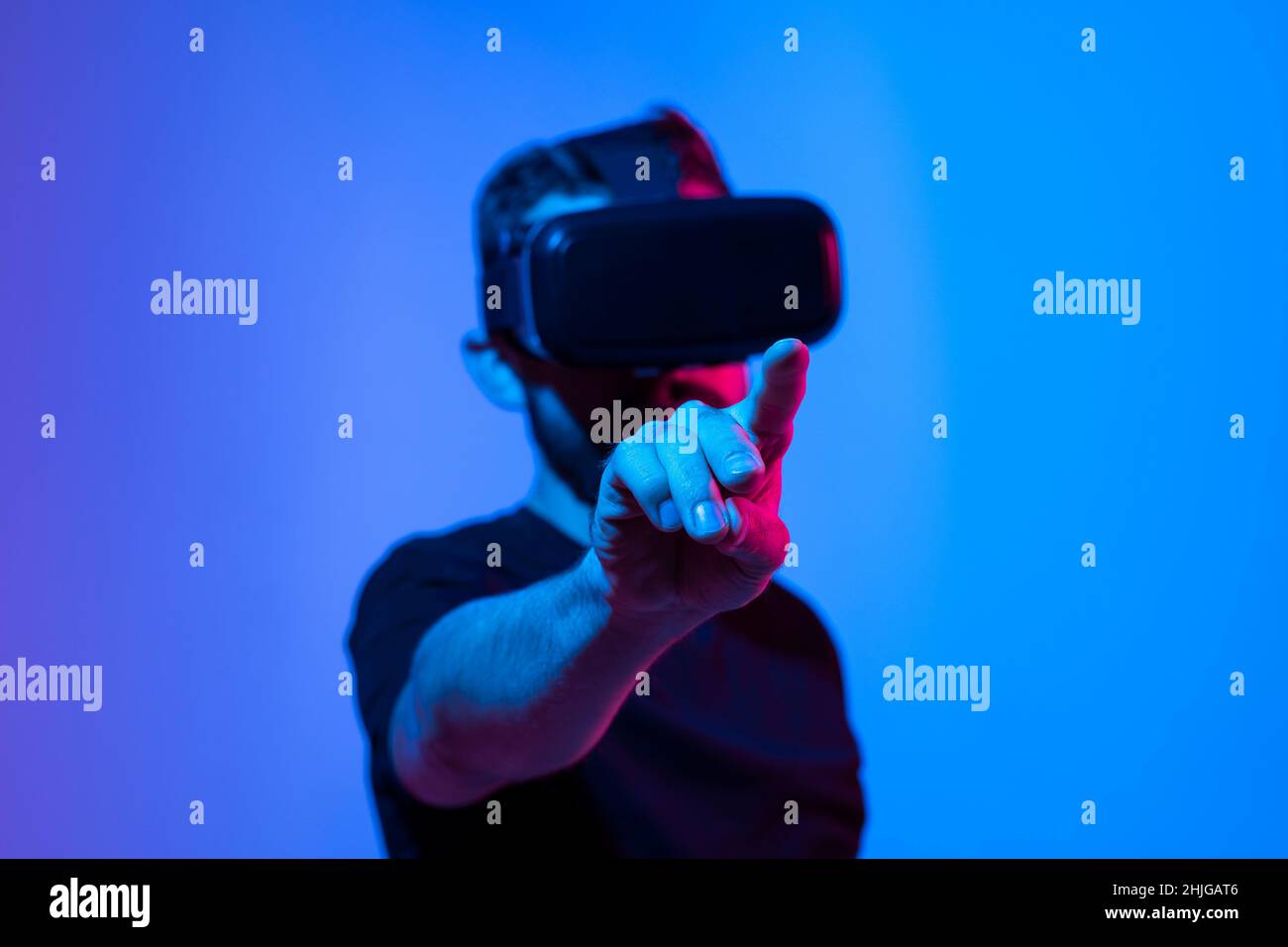 Tecnologia futura e concetto di business. L'uomo con occhiali di realtà virtuale che toccano qualcosa in uno spazio virtuale. Foto Stock