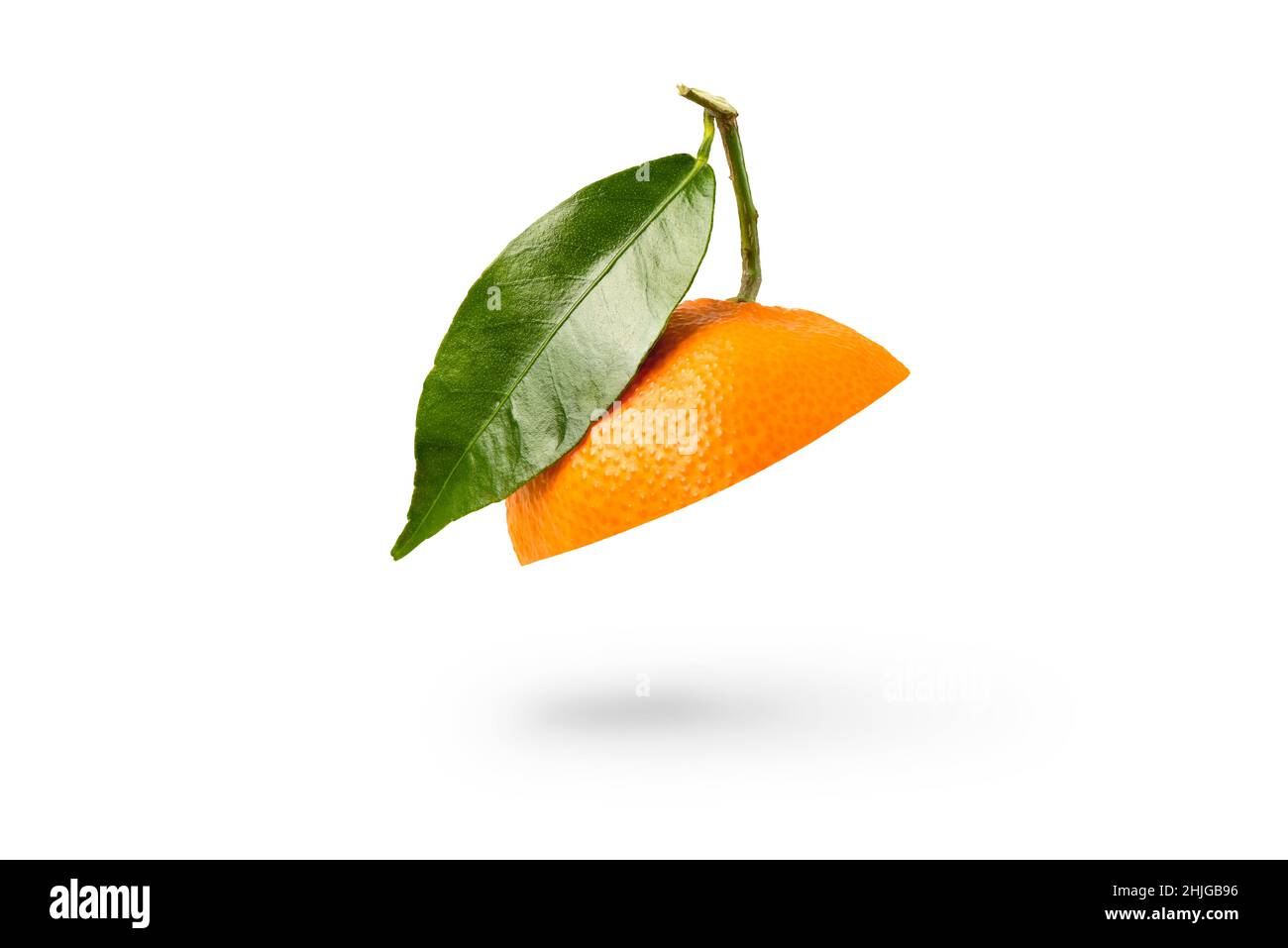 Mandarino tagliato a metà con una foglia verde. Mandarino fresco su sfondo bianco isolato. Concetto di bocca aperta. Texture tangerine close up. Foto Stock