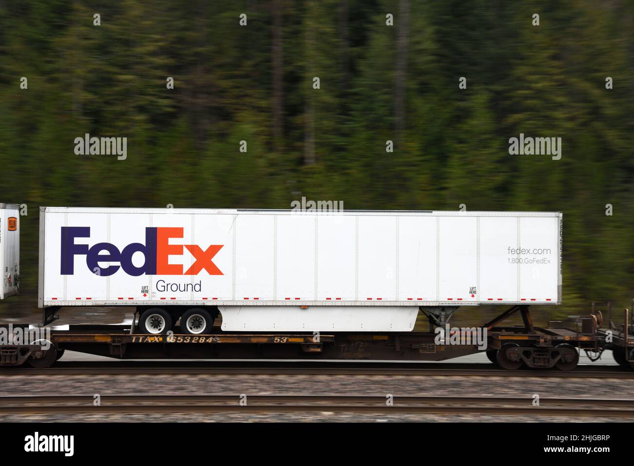 Un container di spedizione intermodale FedEx sulla ferrovia BNSF lungo la loro rotta transcon Nord che corre da Seattle a Chicago. Vicino a Troy, Montana. Foto Stock