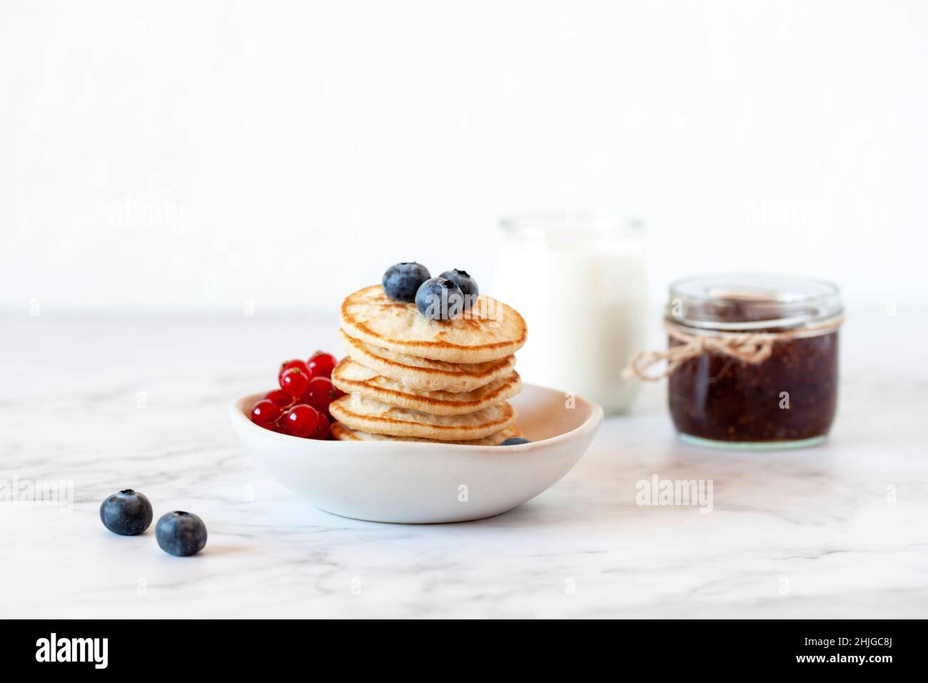 stack di pancake senza glutine decorate con mirtilli e ribes rosso, fuoco selettivo Foto Stock