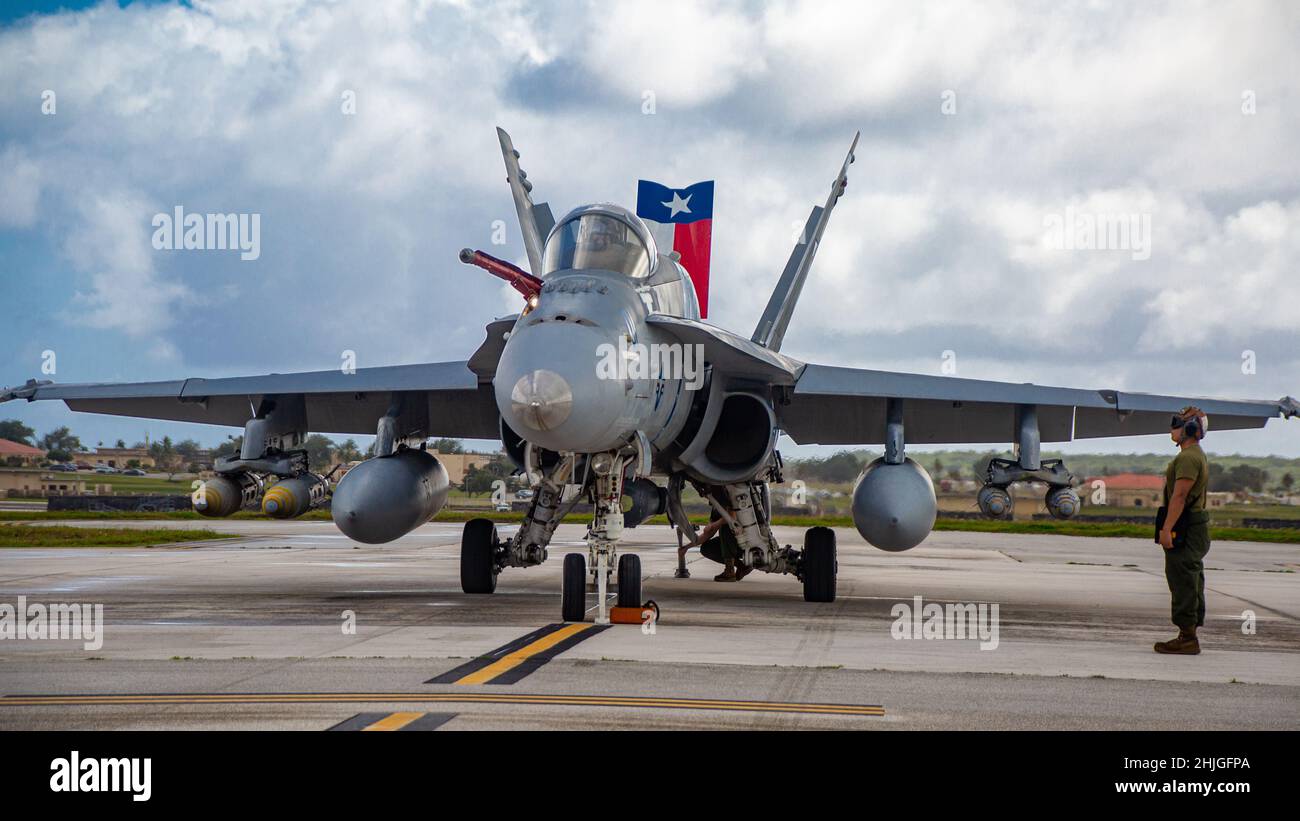 US Marine Corps Lance CPL. Lorenzo Nunez, un meccanico Powerline con Marine Fighter Attack Squadron 112, osserva che l'equipaggio esegue controlli pre-volo su un aereo F/A-18C Hornet presso la base dell'aeronautica Andersen, Guam, 25 gennaio 2022. I Marines con VMFA-112 stanno effettuando un addestramento a livello di unità presso la base dell'aeronautica di Andersen come parte di un programma di trasferimento di addestramento dell'aviazione. (STATI UNITI Foto del corpo marino di Sgt. Booker T. Thomas III) Foto Stock