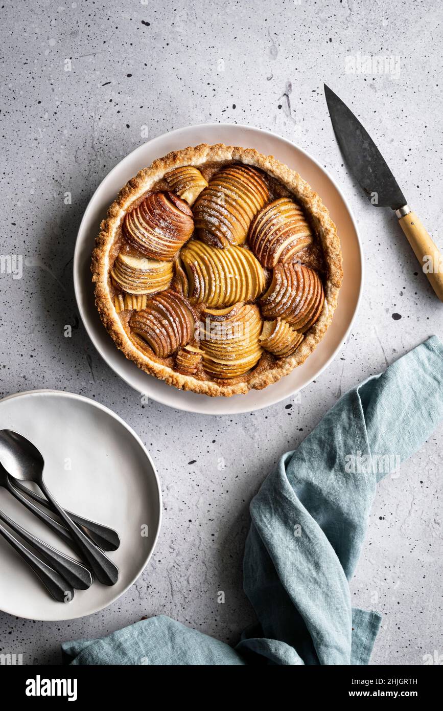 Una torta di mele al forno con piatti da portata e un coltello Foto Stock