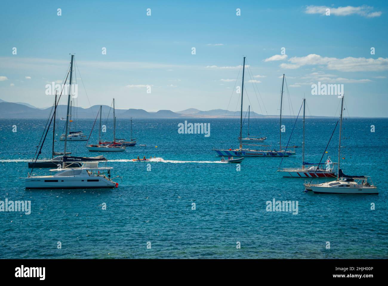 Vista sullo sci d'acqua, barche a vela e Fuerteventura sullo sfondo, Playa Blanca, Lanzarote, Isole Canarie, Spagna, Atlantico, Europa Foto Stock