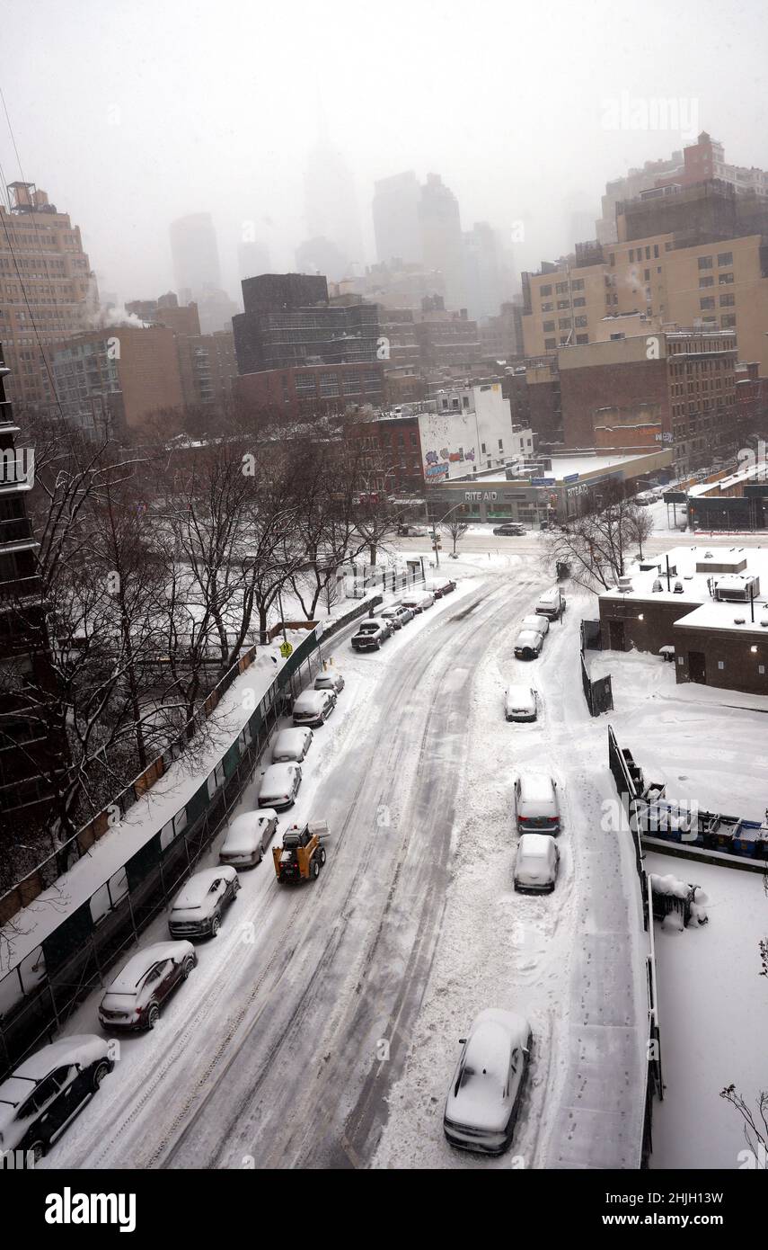 New York City, New York, Stati Uniti. 29th Jan, 2022. Un aratro da neve solato fa la sua strada lungo una strada nella sezione Chelsea di Manhattan il Sabato, Gennaio 29th. Vicino a 12 pollici di neve cadde su New York City durante una bufera che copriva il nord-est degli Stati Uniti. Credit: Adam Stoltman/Alamy Live News Foto Stock
