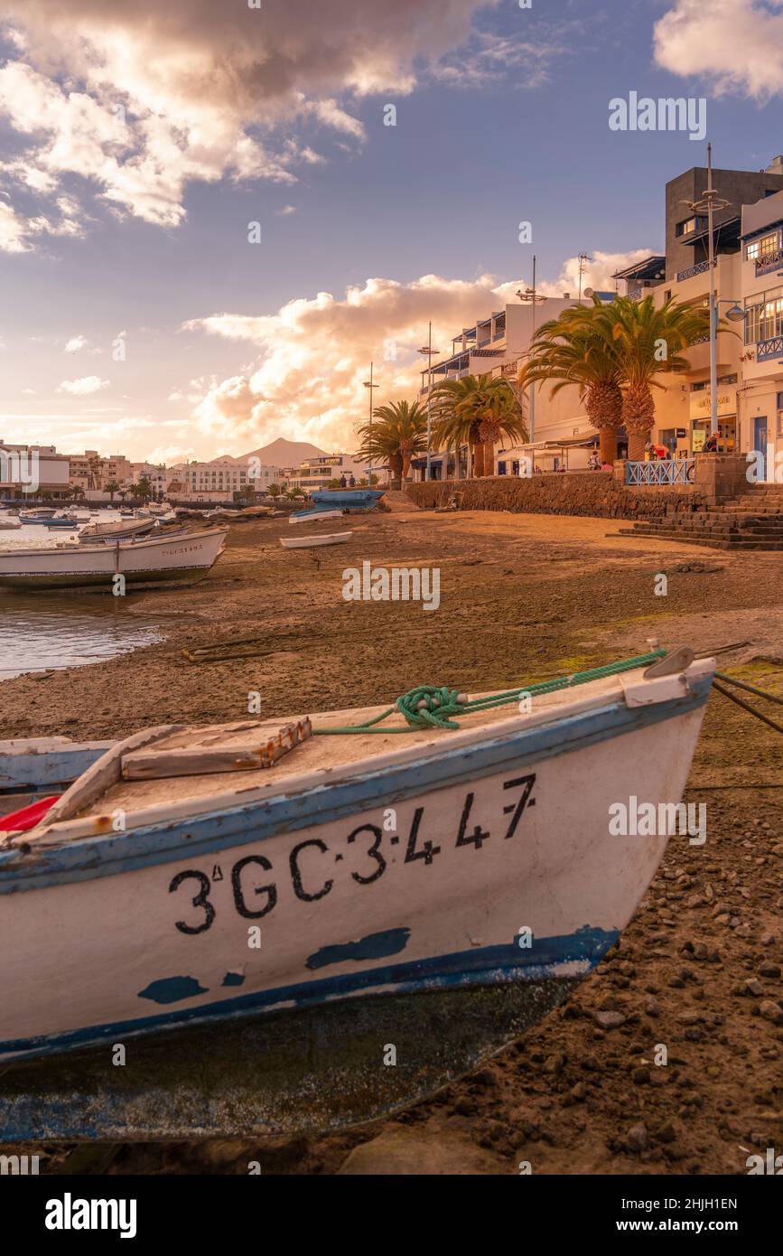 Vista sulla spiaggia di Bahía de Arrecife Marina circondata da negozi, bar e ristoranti al tramonto, Arracife, Lanzarote, Isole Canarie, Spagna, Europa Foto Stock