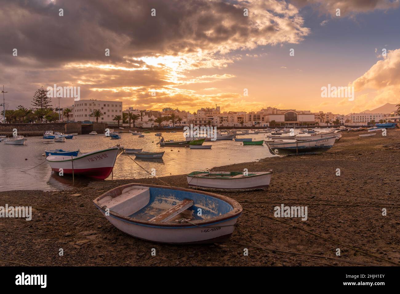 Vista sulla spiaggia di Bahía de Arrecife Marina circondata da negozi, bar e ristoranti al tramonto, Arracife, Lanzarote, Isole Canarie, Spagna, Europa Foto Stock