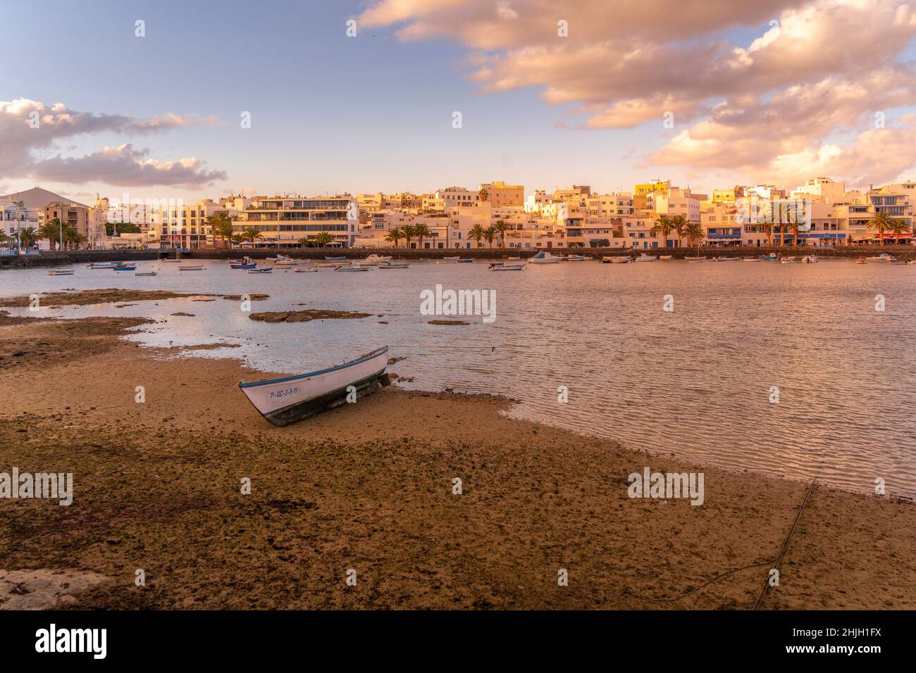 Vista sulla spiaggia di Bahía de Arrecife Marina circondata da negozi, bar e ristoranti al tramonto, Arracife, Lanzarote, Isole Canarie, Spagna, Europa Foto Stock