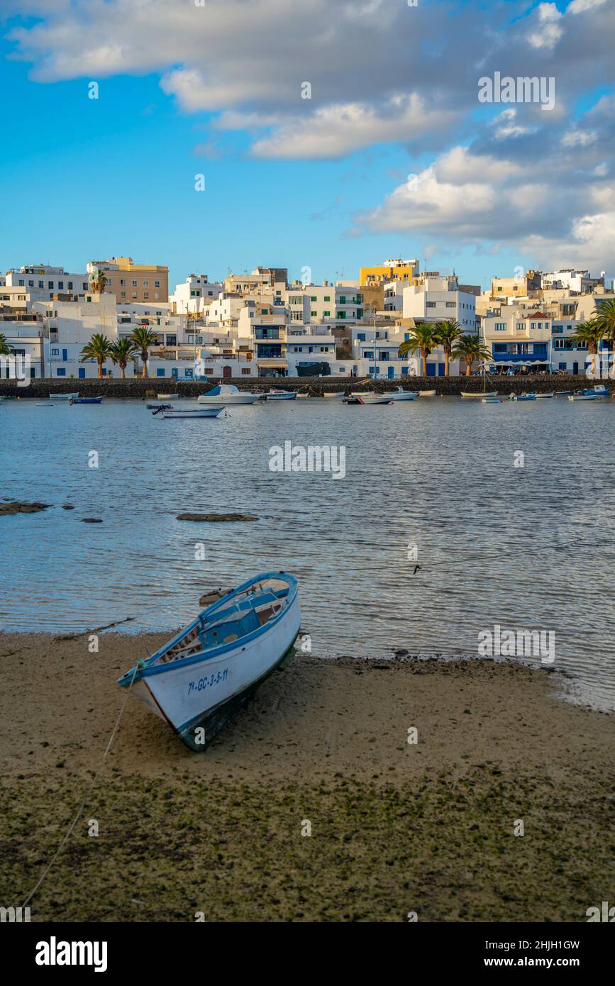 Vista sulla spiaggia di Bahía de Arrecife Marina circondata da negozi, bar e ristoranti al tramonto, Arracife, Lanzarote, Isole Canarie, Spagna, Europa Foto Stock