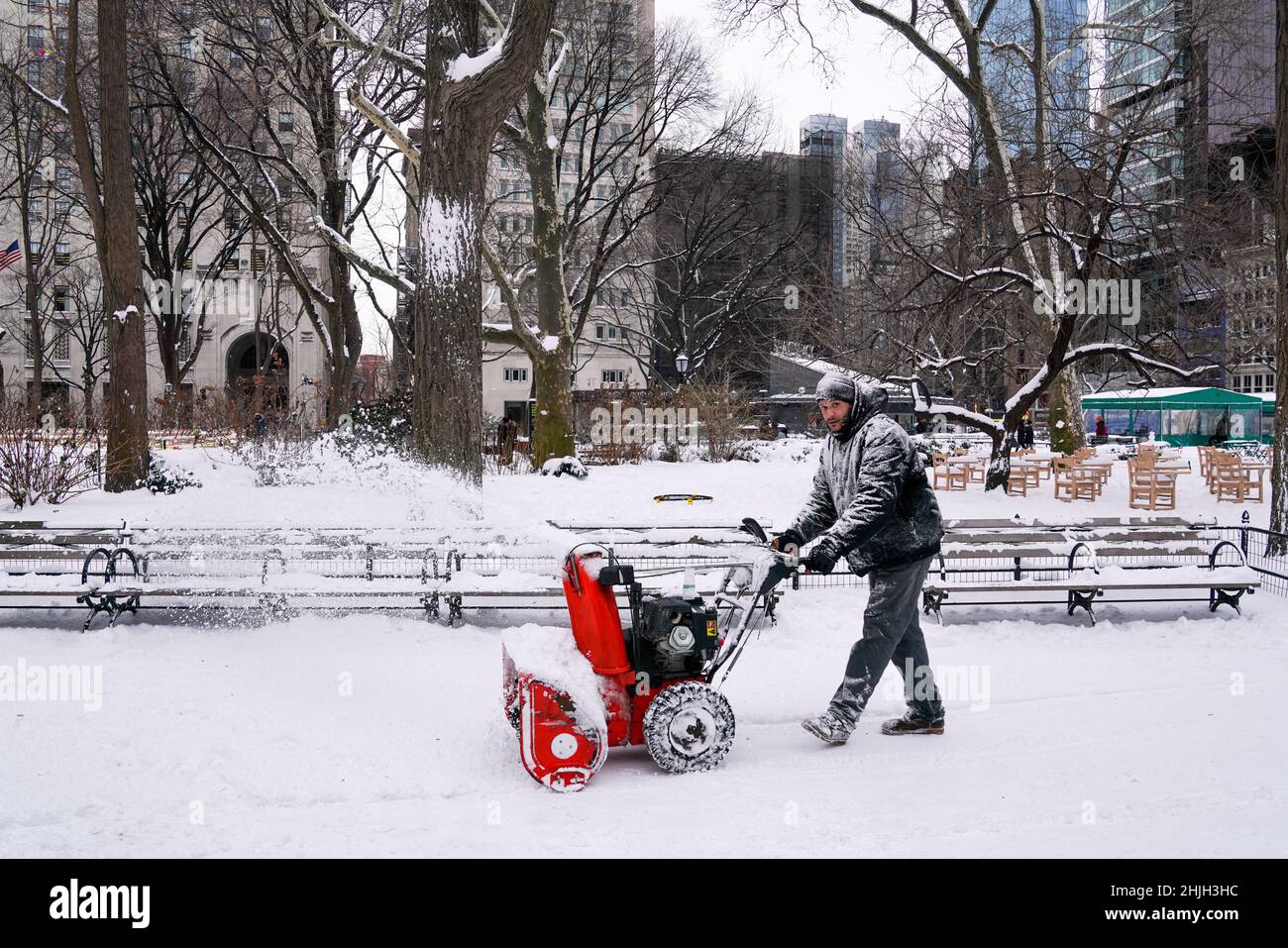 Madison Square Park dopo una tempesta invernale: Il dipendente del parco rimuove la neve dal marciapiede utilizzando una spazzaneve. Foto Stock