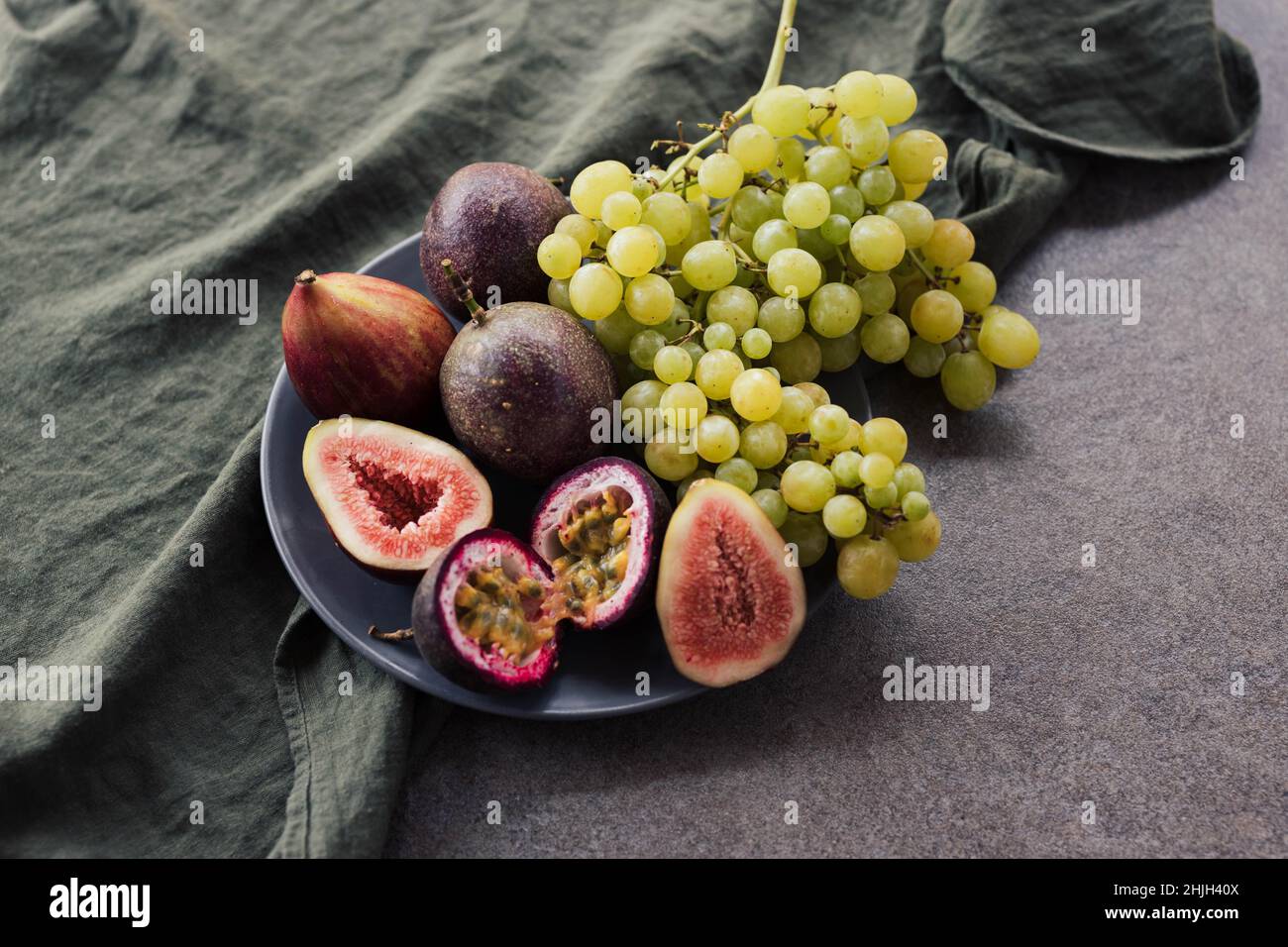Piatto con uva fichi e frutto della passione Foto Stock