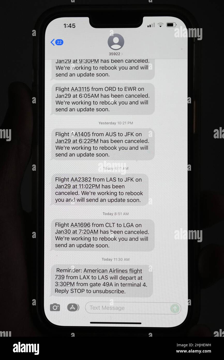 Le cancellazioni dei voli di American Airlines verso gli aeroporti della zona di New York, John F. Kennedy (JFK) e LaGuardia (LGA), in mezzo a una tempesta invernale bufera di neve e vento vengono visualizzate in messaggi di testo su un iPhone 13 Pro Max, sabato 29 gennaio 2022, a Los Angeles. Foto Stock