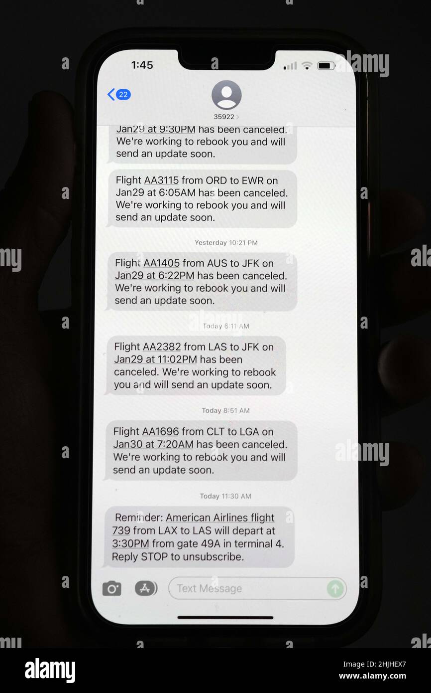 Le cancellazioni dei voli di American Airlines verso gli aeroporti della zona di New York, John F. Kennedy (JFK) e LaGuardia (LGA), in mezzo a una tempesta invernale bufera di neve e vento vengono visualizzate in messaggi di testo su un iPhone 13 Pro Max, sabato 29 gennaio 2022, a Los Angeles. Foto Stock