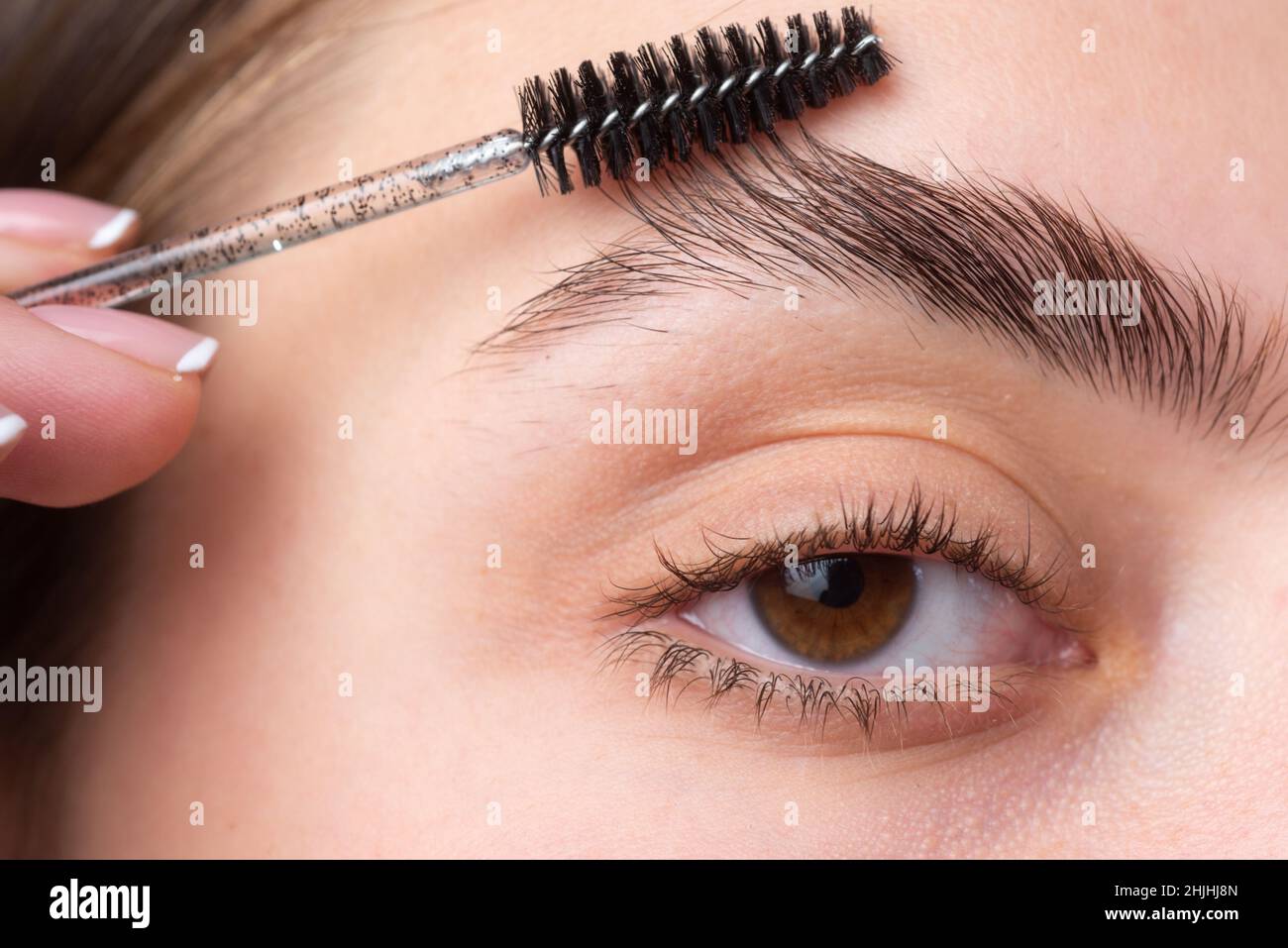 Modellare le sopracciglia, splendida signora affascinante con viso di  bellezza, pelle sana e chiara, tiene la spazzola in mano e dipinge le  sopracciglia. Macro primo piano delle ciglia Foto stock - Alamy