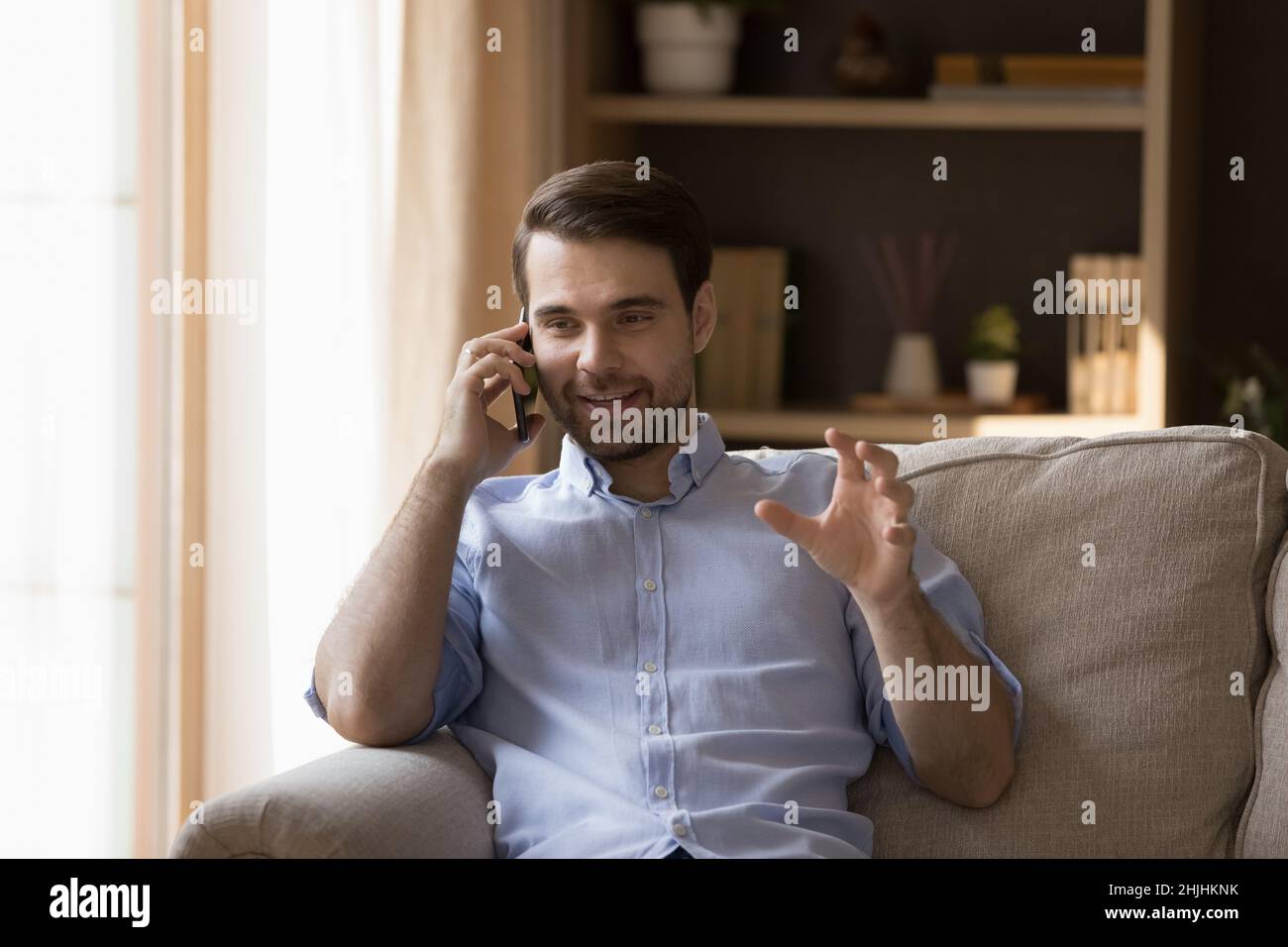 Rilassato felice uomo caucasico tenendo cellulare conversazione. Foto Stock