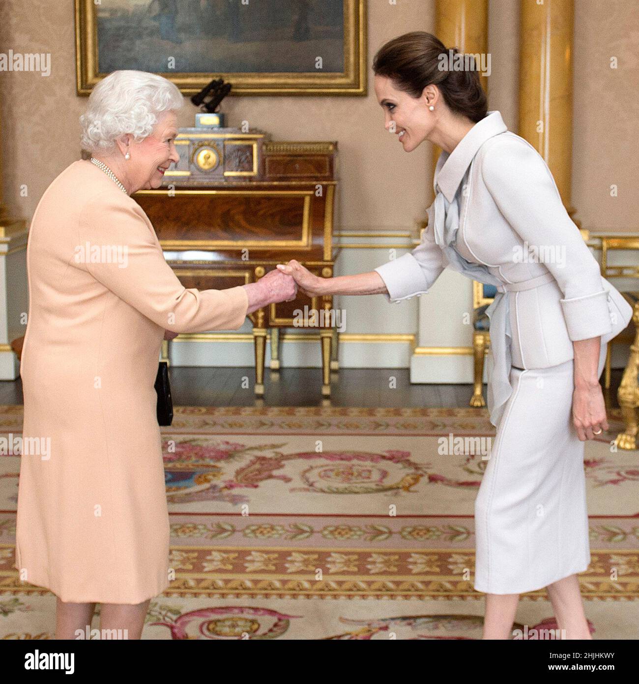 Foto di archivio datata 10/10/14 dell'attrice Angelina Jolie (destra) presentata con l'insegna di un comandante onorario Dame dell'ordine più distinto di San Michele e San Giorgio della Regina Elisabetta II nella stanza 1844 a Buckingham Palace, Londra. Data di emissione: Domenica 30 gennaio 2022. Foto Stock
