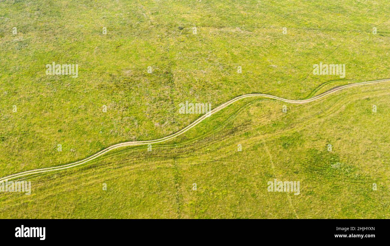 La pista agricola si piega attraverso il campo e sembra un serpente Foto Stock