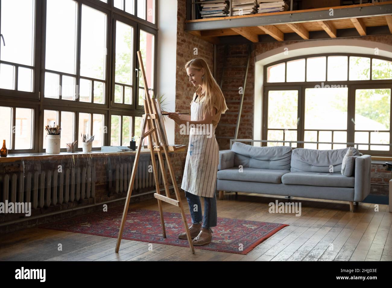 Giovane artista indie donna che lavora in studio, pittura immagine Foto Stock