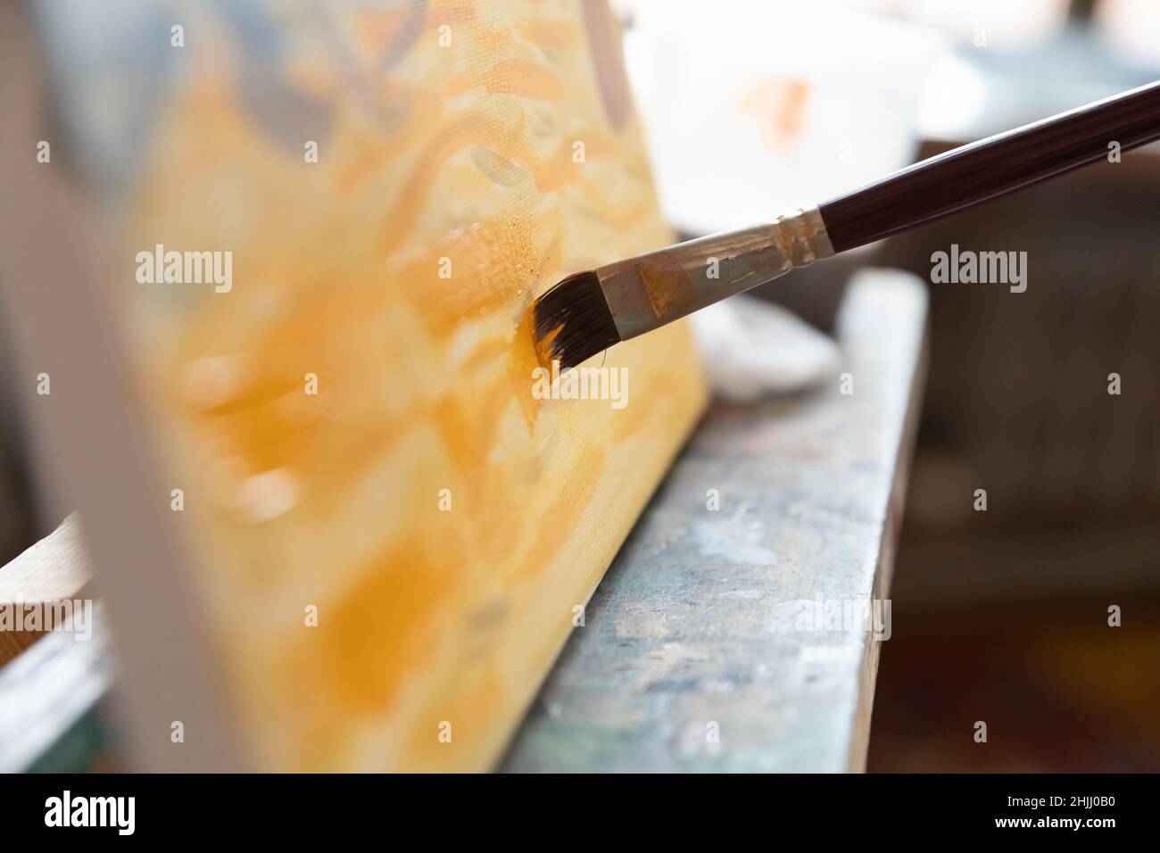 Primo piano delle setole del pennello che toccano la tela Foto Stock