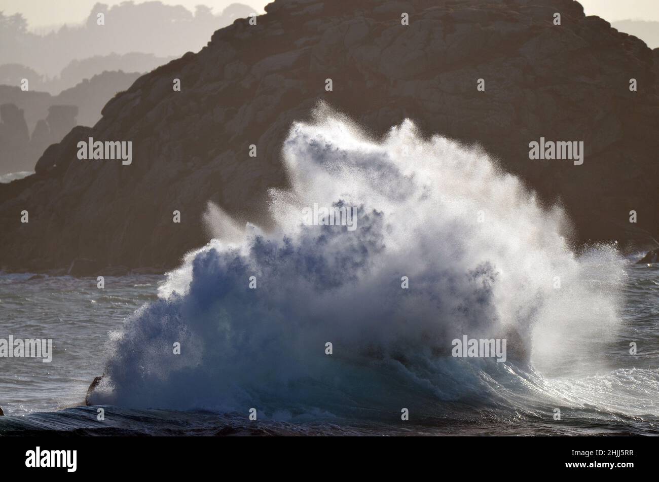 Esplosione di un'onda contro la costa rocciosa in Bretagna, Francia. Foto Stock