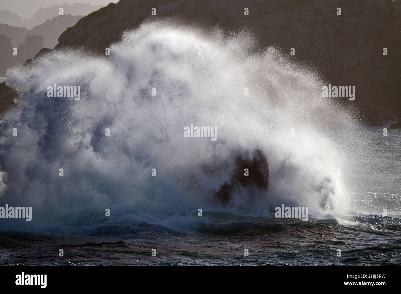 Esplosione di un'onda contro la costa rocciosa in Bretagna, Francia. Foto Stock