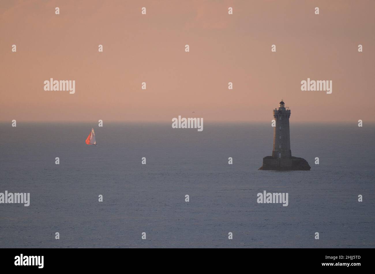 Una barca a vela solitaria nella baia di Douarnenez, Bretagna, durante il tramonto. Foto Stock