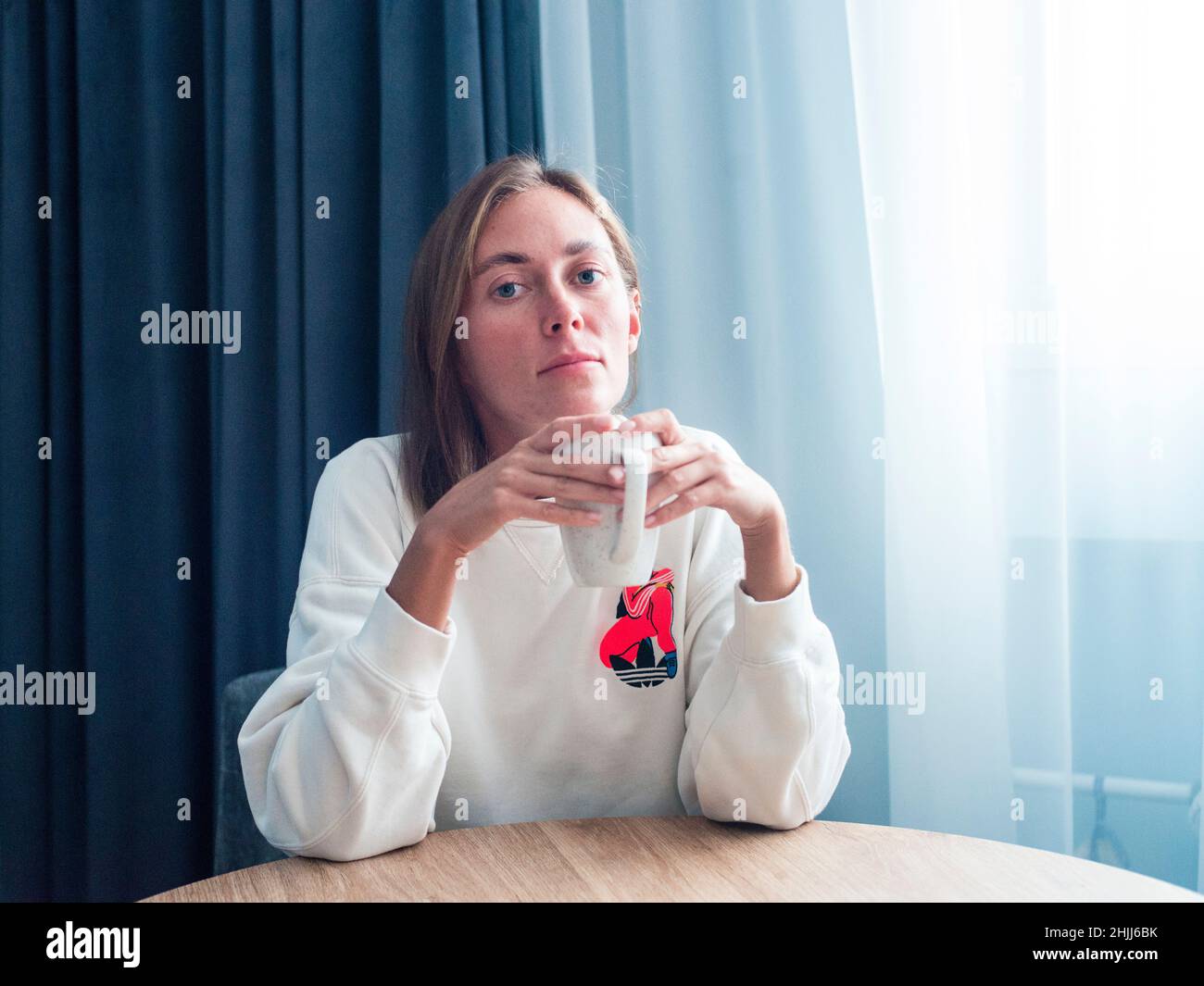 Giovane donna che tiene la tazza rilasciata Foto Stock