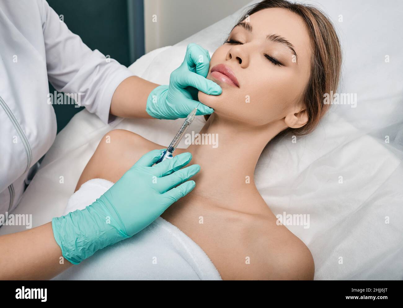 Donna lifting mento e viso inferiore utilizzando l'iniezione di bellezza, non chirurgia. Process lifting viso contorno in cosmetologia, primo piano Foto Stock