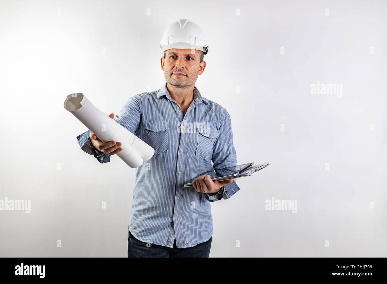Ingegnere civile maschile di mezza età con blueprint nelle mani e con un casco bianco rigido. Ritratto isolato su sfondo bianco. Materiale maschio ph Foto Stock