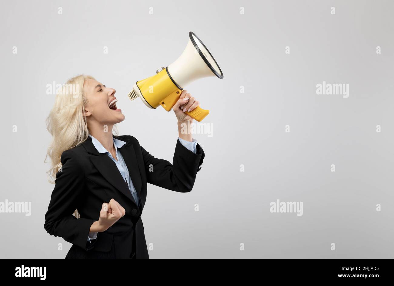 Donna d'affari emozionale urlando con altoparlante, facendo pubblicità o annuncio circa la vendita o lo sconto Foto Stock