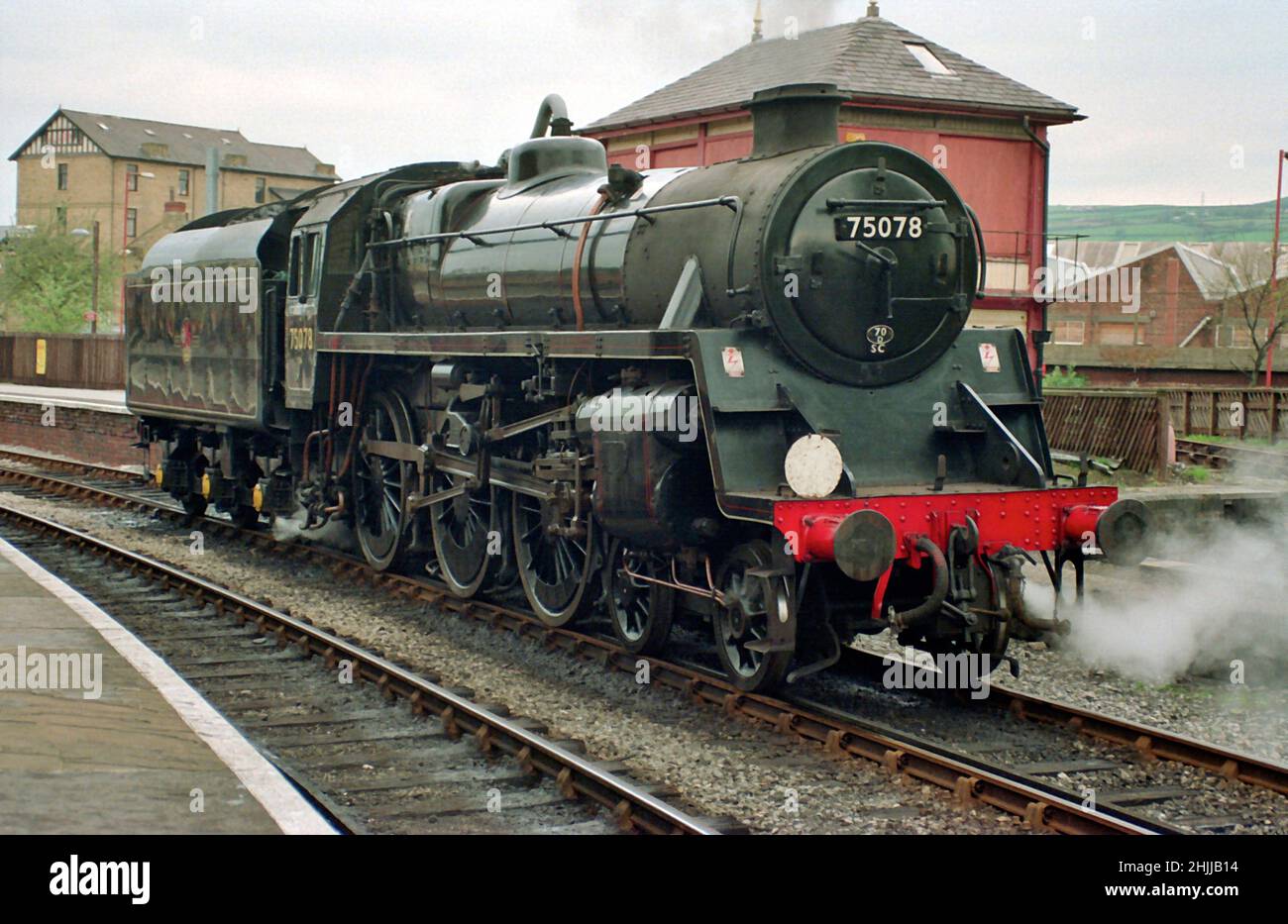 British Railways Standard Class 4mt 4-6-0 la locomotiva a vapore Tender attende il prossimo treno alla stazione di Keighley sul KWVR negli anni '90 Foto Stock