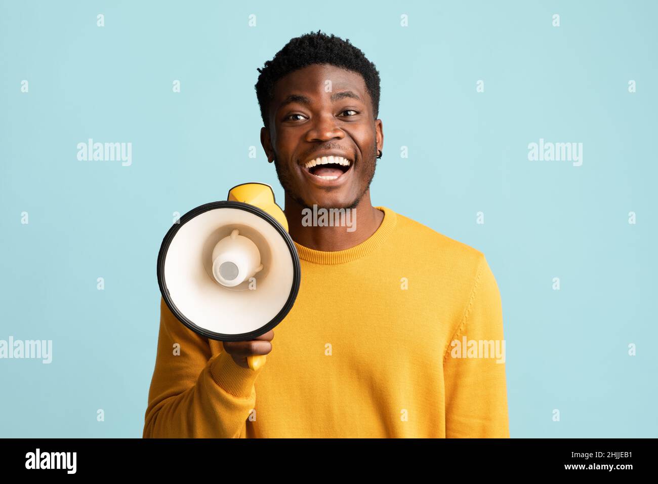 Allegro ragazzo nero con megaphone che fa annuncio Foto Stock
