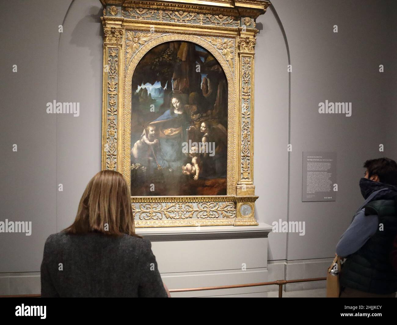 I visitatori studiano la Vergine delle rocce del pittore rinascimentale italiano Leonardo da Vinci alla National Gallery di Londra, Regno Unito Foto Stock