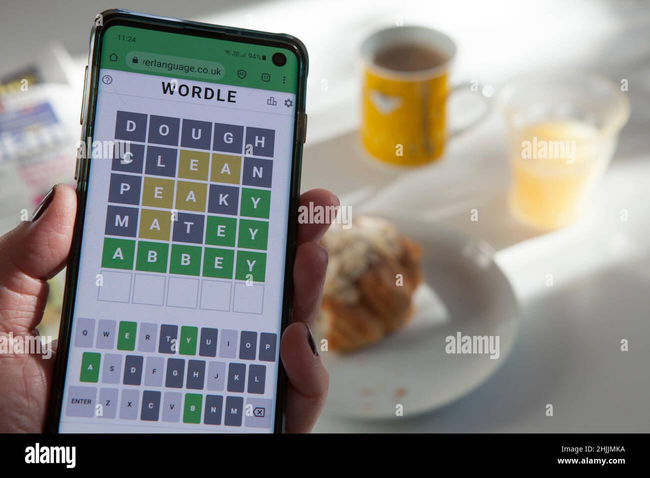 Un giocatore di Wortle fa il puzzle quotidiano della parola sopra la colazione. Il gioco, creato da Josh Wardle, è stato venduto al New York Times. Anna Watson/Alamy Foto Stock