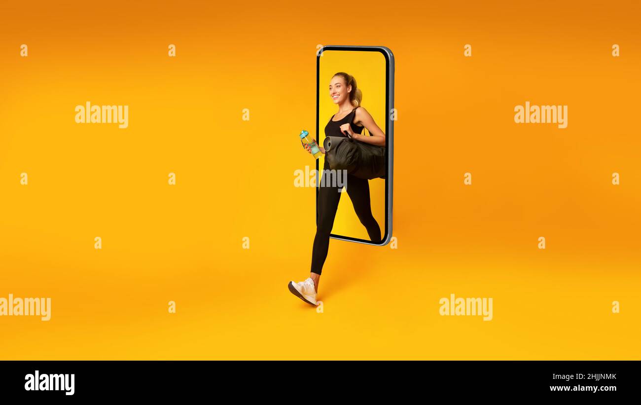 Signora sportiva che cammina fuori dallo schermo del telefono su sfondo giallo Foto Stock