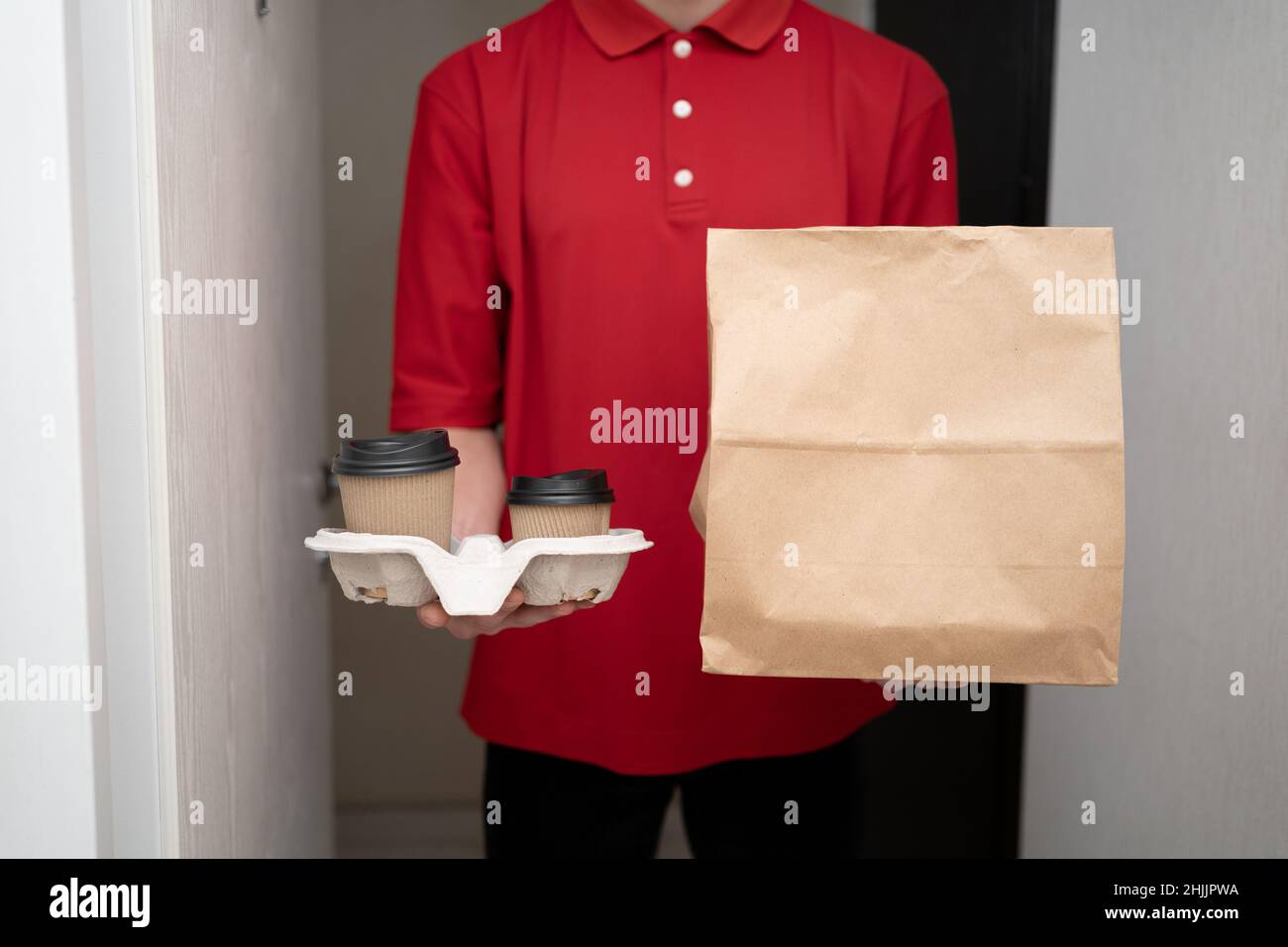 consegna cibo a casa, uomo consegna di cibo e caffè, corriere in uniforme senza testa, ristorante takeaway ordine Foto Stock